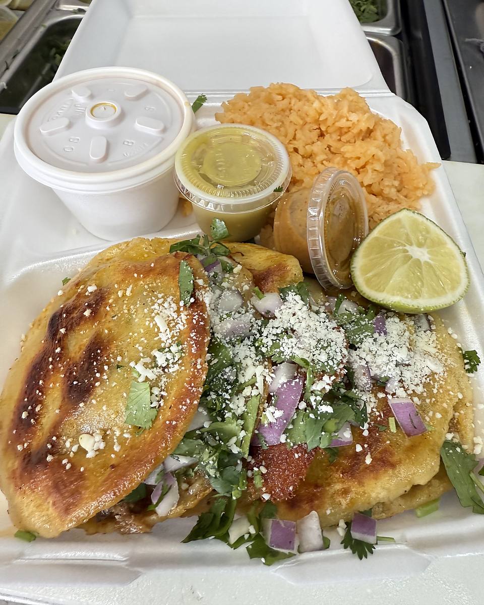 Photo from La TacoTrona's own Google listing: a quesabirria plate in a takeout tray with red rice, a lime wedge, salsa cups and a cup of consome.